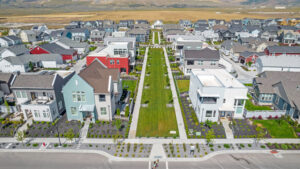 An aerial view of the Contempo Collection in Daybreak reveals a modern suburban neighborhood with spacious houses surrounding a central green area.