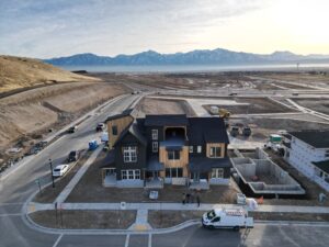 Aerial view of a suburban house under construction with mountains in the background.