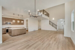 Modern open living space with wood floors, a kitchen island, and pendant lights—its a true Nightingales nest of style.